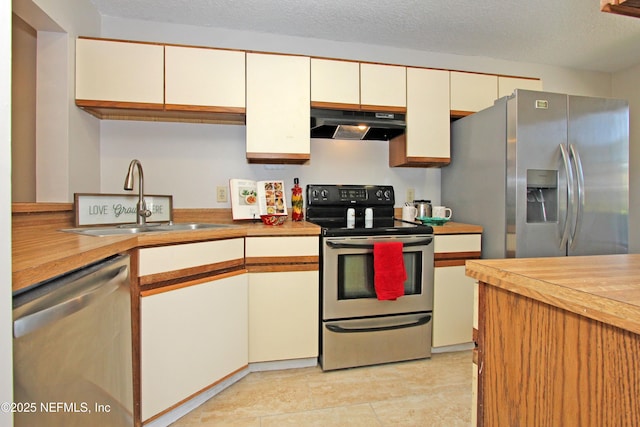 2105 Sandpiper Ct, Ponte Vedra Beach, FL 32082 - kitchen featuring under cabinet range hood, stainless steel appliances, a sink, light countertops, and white cabinetry