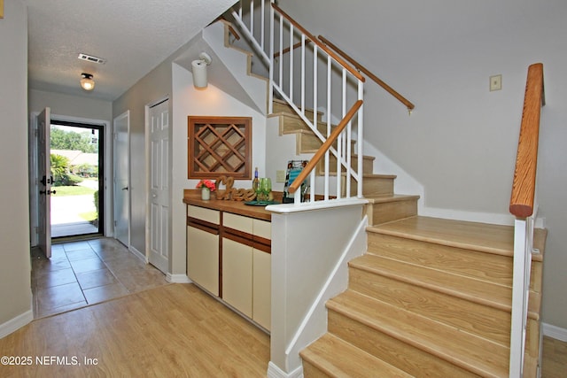 2105 Sandpiper Ct, Ponte Vedra Beach, FL 32082 - entryway with stairway, baseboards, light wood-type flooring, and a textured ceiling