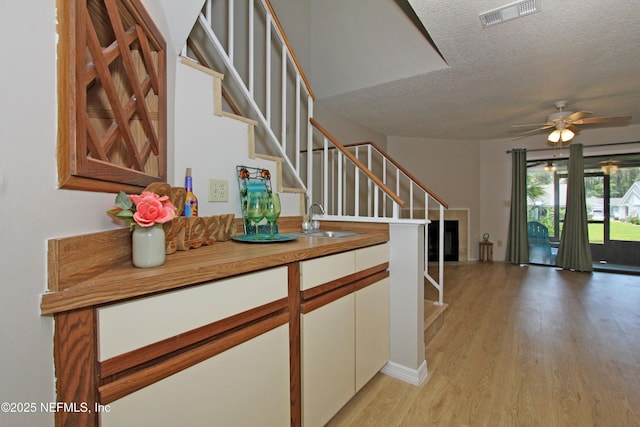 2105 Sandpiper Ct, Ponte Vedra Beach, FL 32082 - hall featuring a sink, a textured ceiling, stairs, and light wood-style flooring