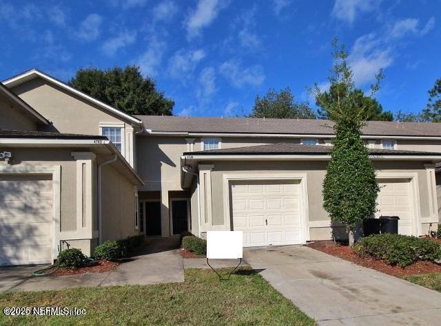 4778 Playpen Dr, Jacksonville, FL 32210 - view of front of home featuring stucco siding, driveway, and a garage