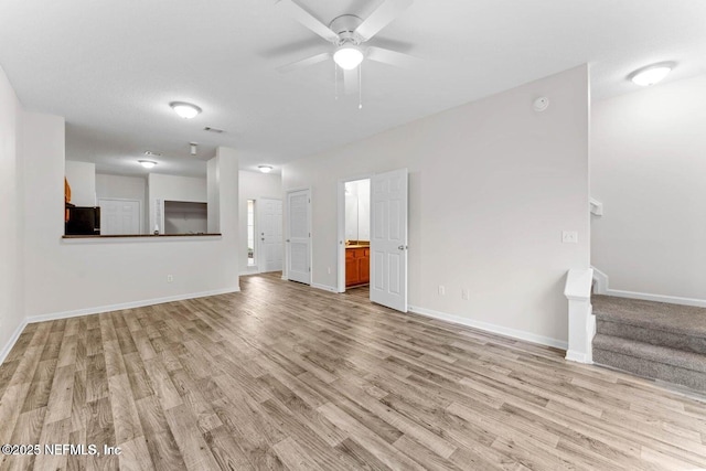 4778 Playpen Dr, Jacksonville, FL 32210 - unfurnished living room with light wood-style flooring, baseboards, stairway, and a ceiling fan
