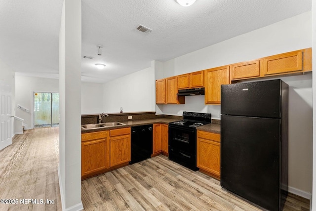 4778 Playpen Dr, Jacksonville, FL 32210 - kitchen featuring black appliances, a sink, under cabinet range hood, light wood-type flooring, and dark countertops