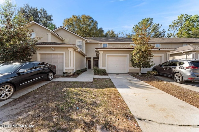4778 Playpen Dr, Jacksonville, FL 32210 - view of property with concrete driveway, stucco siding, and a garage