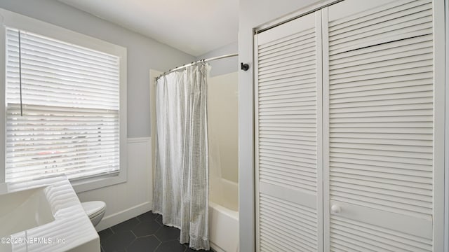 119 Moore St, Saint Augustine, FL 32084 - bathroom with toilet, shower / tub combo with curtain, tile patterned floors, wainscoting, and a closet