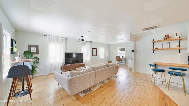 119 Moore St, Saint Augustine, FL 32084 - living room with light wood finished floors, a textured ceiling, and baseboards