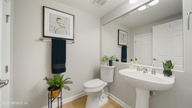 18 Amistad Dr, Saint Augustine, FL 32086 - half bath with toilet, a textured ceiling, tile patterned floors, and baseboards