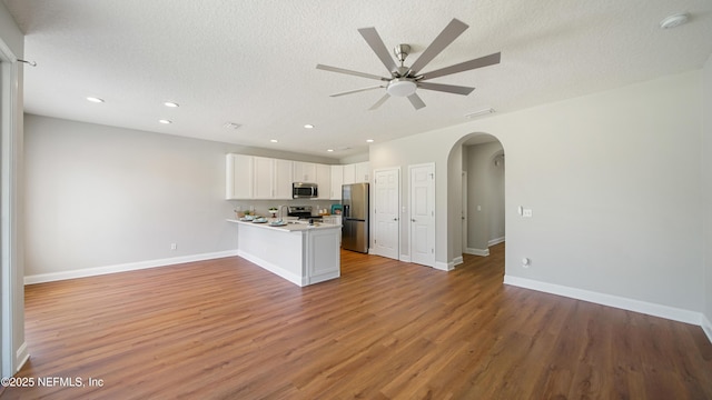 18 Amistad Dr, Saint Augustine, FL 32086 - kitchen with stainless steel appliances, arched walkways, a peninsula, open floor plan, and white cabinets