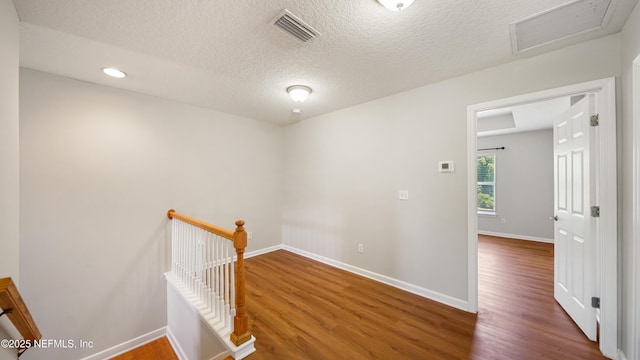 18 Amistad Dr, Saint Augustine, FL 32086 - corridor featuring an upstairs landing, wood finished floors, attic access, baseboards, and a textured ceiling
