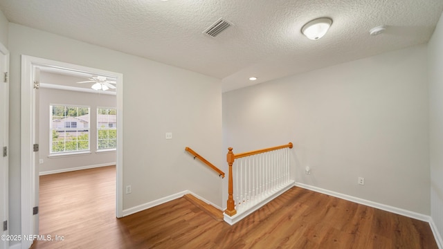 18 Amistad Dr, Saint Augustine, FL 32086 - hallway with an upstairs landing, wood finished floors, baseboards, a textured ceiling, and recessed lighting
