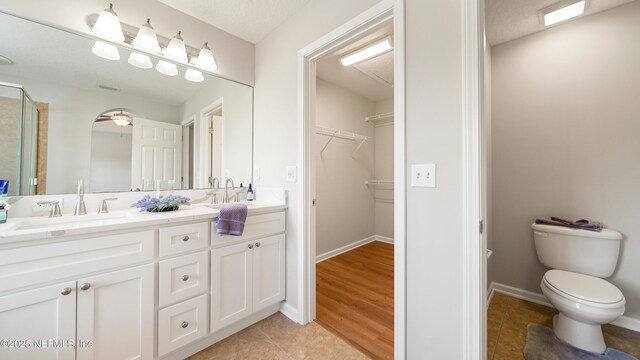 18 Amistad Dr, Saint Augustine, FL 32086 - bathroom with double vanity, toilet, a spacious closet, an enclosed shower, and tile patterned flooring