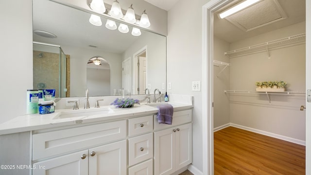 18 Amistad Dr, Saint Augustine, FL 32086 - full bathroom featuring double vanity, a shower stall, wood finished floors, a spacious closet, and baseboards
