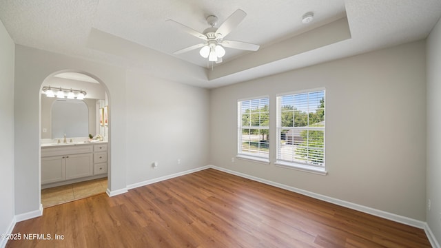 18 Amistad Dr, Saint Augustine, FL 32086 - unfurnished bedroom with a tray ceiling, wood finished floors, a sink, and baseboards