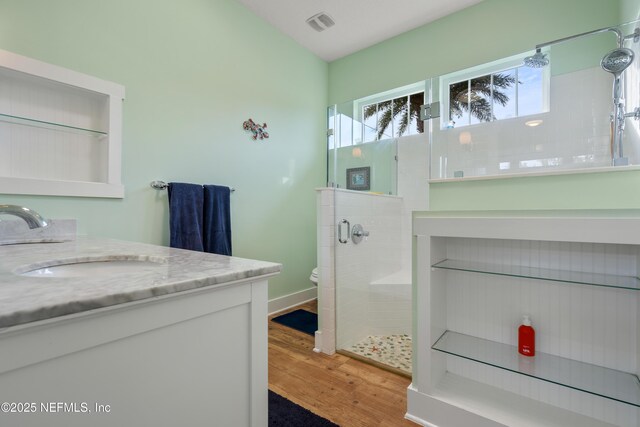 211 Tenth St, Saint Augustine, FL 32084 - bathroom with vanity, a shower stall, toilet, and wood finished floors