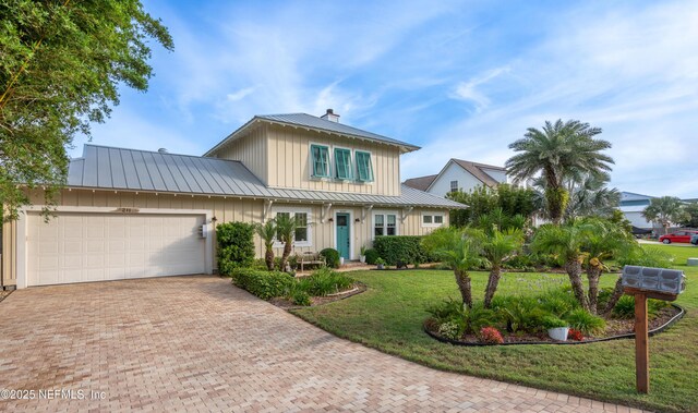 211 Tenth St, Saint Augustine, FL 32084 - view of front facade with board and batten siding, a standing seam roof, a chimney, metal roof, and decorative driveway