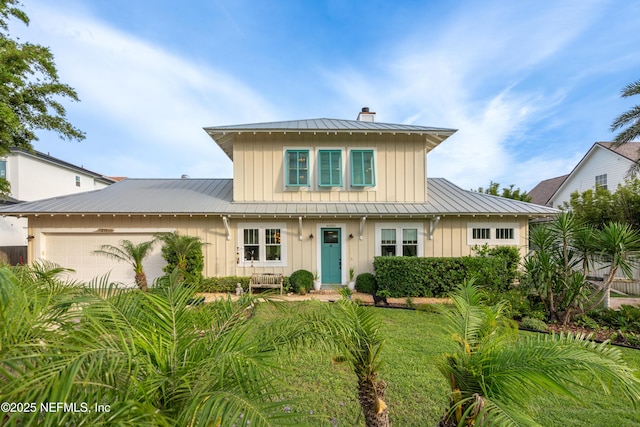 211 Tenth St, Saint Augustine, FL 32084 - view of front of home with board and batten siding, a standing seam roof, a chimney, metal roof, and a garage