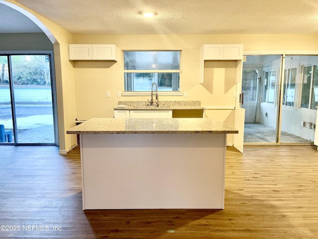 3527 Sheldon Rd, Orange Park, FL 32073 - kitchen featuring a sink, light wood-type flooring, white cabinetry, and a textured ceiling