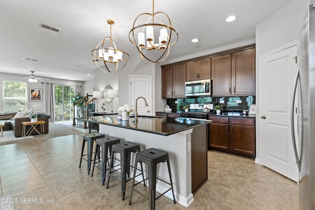 11286 Minnetta Ct, Jacksonville, FL 32256 - kitchen featuring appliances with stainless steel finishes, a sink, a chandelier, a kitchen breakfast bar, and decorative backsplash