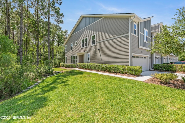11286 Minnetta Ct, Jacksonville, FL 32256 - view of property exterior featuring concrete driveway, a garage, a yard, and board and batten siding