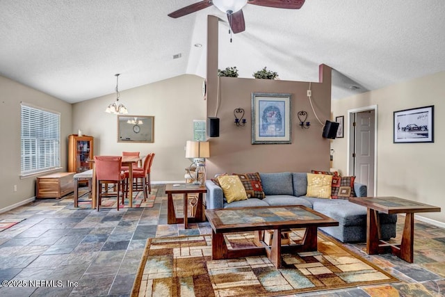 7041 Catlett Rd, Saint Augustine, FL 32095 - living area featuring baseboards, stone tile flooring, a textured ceiling, lofted ceiling, and a ceiling fan