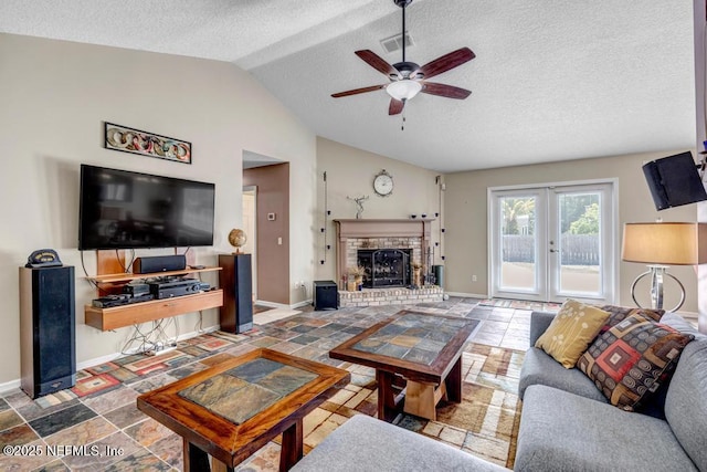 7041 Catlett Rd, Saint Augustine, FL 32095 - living area featuring lofted ceiling, ceiling fan, a textured ceiling, french doors, and a fireplace