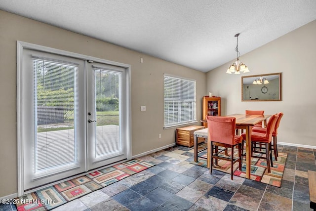 7041 Catlett Rd, Saint Augustine, FL 32095 - dining space with stone tile floors, baseboards, a textured ceiling, french doors, and a chandelier