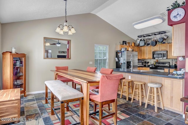 7041 Catlett Rd, Saint Augustine, FL 32095 - dining area featuring stone tile flooring, vaulted ceiling, a chandelier, and baseboards