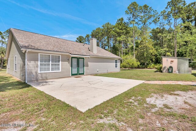 7041 Catlett Rd, Saint Augustine, FL 32095 - back of house with a yard, a chimney, a patio area, and a shingled roof