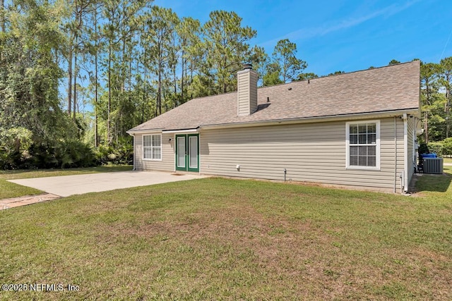 7041 Catlett Rd, Saint Augustine, FL 32095 - back of house featuring central AC, a patio area, a lawn, a chimney, and roof with shingles