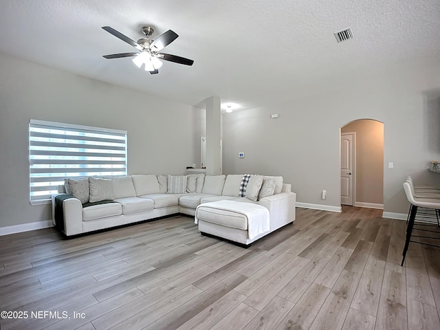 9413 Alma St, Jacksonville, FL 32220 - living room with wood finished floors, arched walkways, a ceiling fan, a textured ceiling, and baseboards