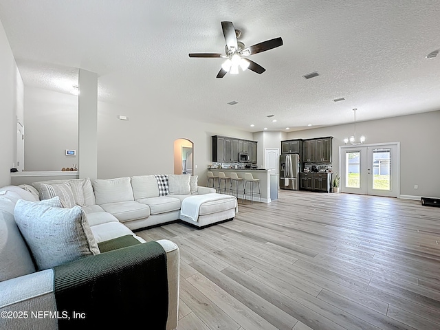 9413 Alma St, Jacksonville, FL 32220 - living room featuring a ceiling fan, a textured ceiling, light wood-type flooring, arched walkways, and french doors