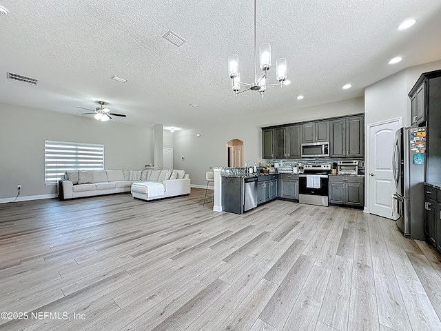 9413 Alma St, Jacksonville, FL 32220 - kitchen with stainless steel appliances, open floor plan, light wood-type flooring, a chandelier, and a peninsula