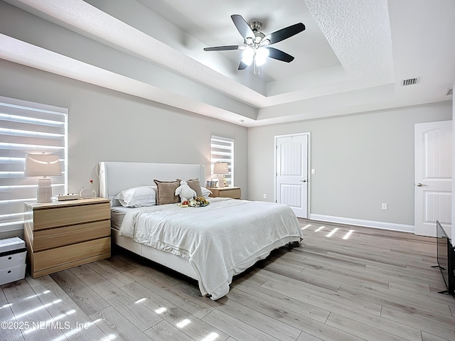 9413 Alma St, Jacksonville, FL 32220 - bedroom featuring a tray ceiling, light wood finished floors, baseboards, and ceiling fan