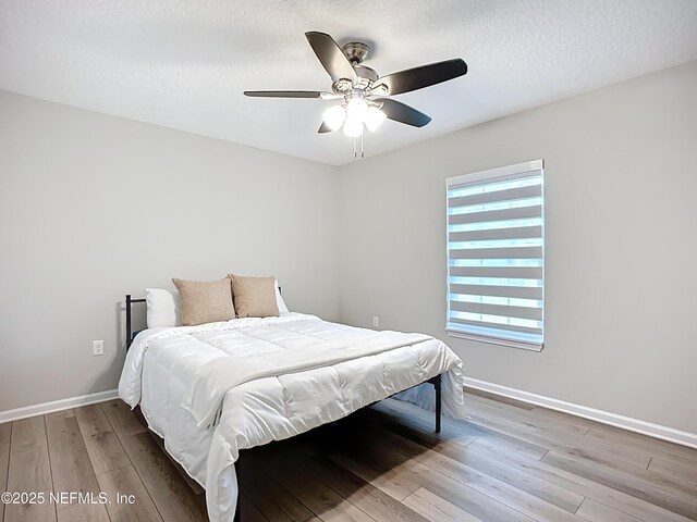 9413 Alma St, Jacksonville, FL 32220 - bedroom with wood finished floors, baseboards, ceiling fan, and a textured ceiling