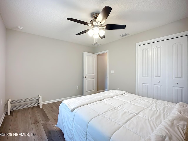 9413 Alma St, Jacksonville, FL 32220 - bedroom with wood finished floors, a closet, baseboards, a ceiling fan, and a textured ceiling