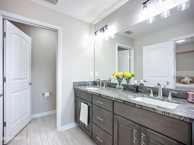 9413 Alma St, Jacksonville, FL 32220 - bathroom featuring double vanity, baseboards, and a textured ceiling