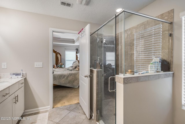 380 Crescent Key Dr, Saint Augustine, FL 32086 - ensuite bathroom featuring vanity, tile patterned floors, a stall shower, baseboards, and a textured ceiling