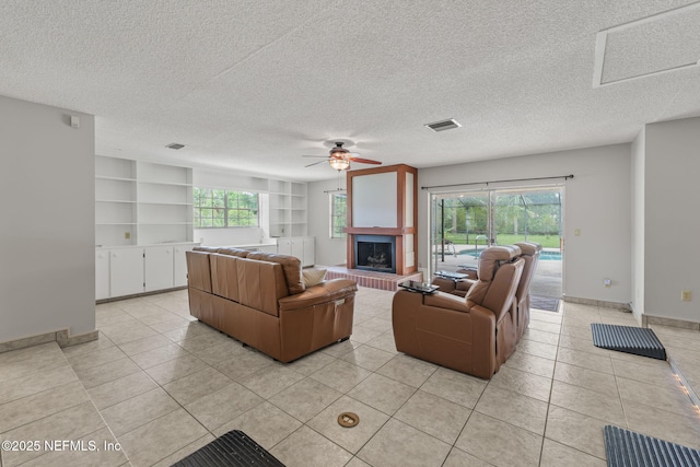 419 Sevilla Dr, Saint Augustine, FL 32086 - living area featuring ceiling fan, light tile patterned floors, a textured ceiling, baseboards, and a fireplace with raised hearth