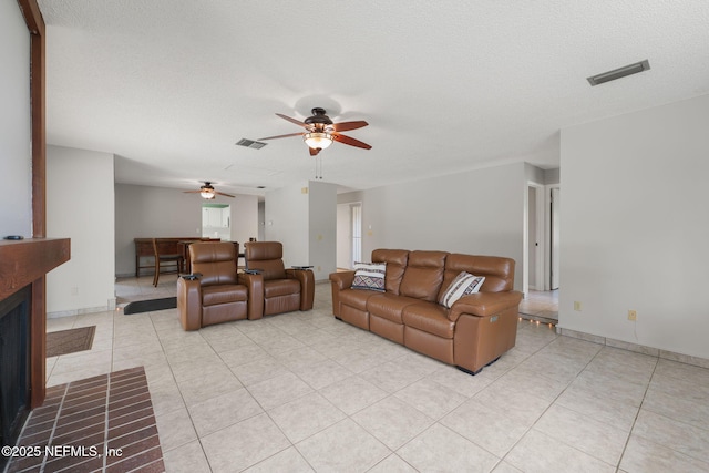 419 Sevilla Dr, Saint Augustine, FL 32086 - living area with a ceiling fan, light tile patterned floors, a textured ceiling, a fireplace with flush hearth, and baseboards