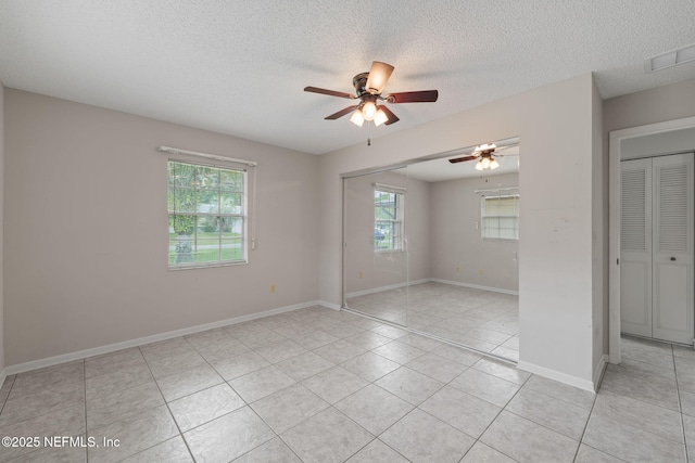 419 Sevilla Dr, Saint Augustine, FL 32086 - unfurnished room with ceiling fan, plenty of natural light, light tile patterned floors, a textured ceiling, and baseboards