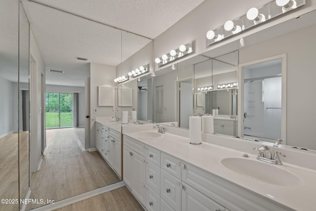 419 Sevilla Dr, Saint Augustine, FL 32086 - bathroom with double vanity, wood finished floors, and a textured ceiling