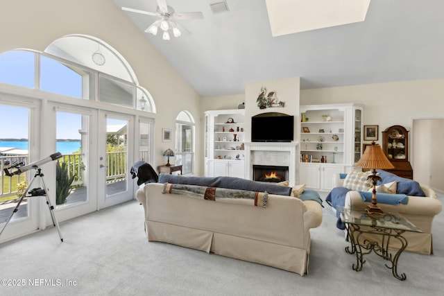 4333 Seminole St, Starke, FL 32091 - carpeted living area with a water view, a lit fireplace, a ceiling fan, a skylight, and french doors