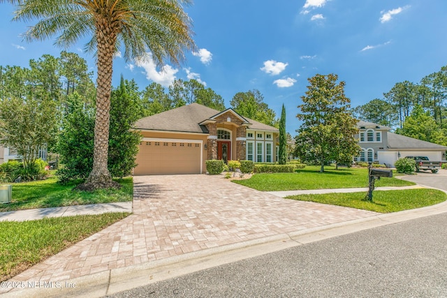 117 Pineta Way, Saint Johns, FL 32259 - view of front of home with decorative driveway, a front yard, a garage, and stone siding