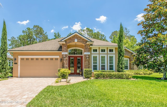 117 Pineta Way, Saint Johns, FL 32259 - view of front of home with french doors, stone siding, an attached garage, and a front lawn