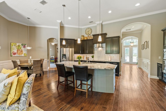 117 Pineta Way, Saint Johns, FL 32259 - kitchen with stainless steel refrigerator with ice dispenser, arched walkways, dark wood-type flooring, a kitchen island with sink, and a wainscoted wall