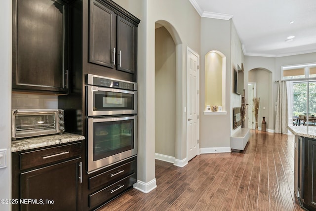 117 Pineta Way, Saint Johns, FL 32259 - kitchen featuring stainless steel double oven, crown molding, dark wood-style flooring, baseboards, and light stone counters