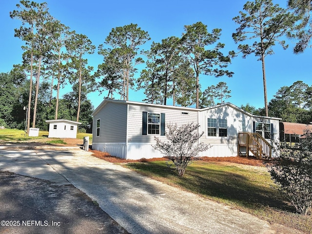 11648 E Confederate Dr, Glen St Mary, FL 32040 - manufactured / mobile home with driveway, an outbuilding, and a front yard
