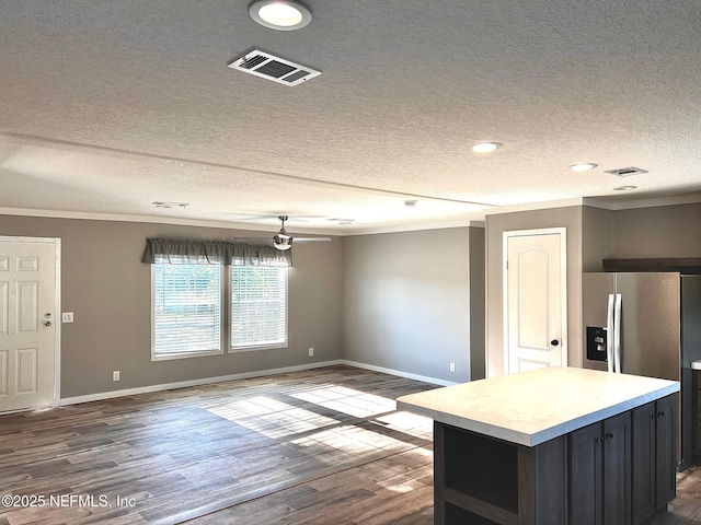 11648 E Confederate Dr, Glen St Mary, FL 32040 - kitchen featuring stainless steel refrigerator with ice dispenser, ornamental molding, a textured ceiling, light countertops, and baseboards