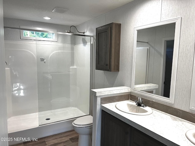 11648 E Confederate Dr, Glen St Mary, FL 32040 - bathroom featuring toilet, a walk in shower, wood finished floors, double vanity, and a textured ceiling