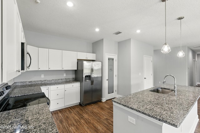 9706 Sibbald Rd, Jacksonville, FL 32219 - kitchen featuring appliances with stainless steel finishes, a sink, dark wood finished floors, dark stone counters, and white cabinetry