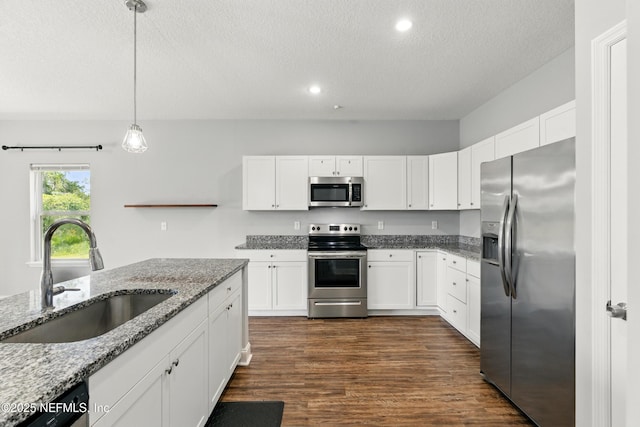 9706 Sibbald Rd, Jacksonville, FL 32219 - kitchen featuring stainless steel appliances, a sink, a textured ceiling, white cabinets, and light stone counters